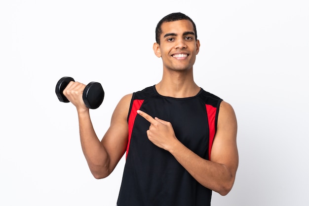 Homme de sport afro-américain sur mur blanc isolé et en le pointant