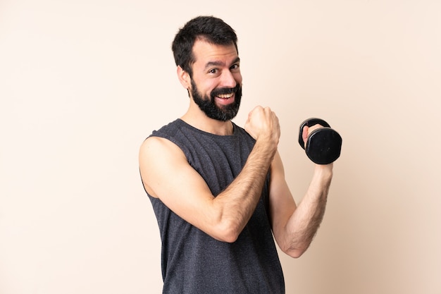 Homme de sport caucasien avec barbe faisant de l'haltérophilie célébrant une victoire