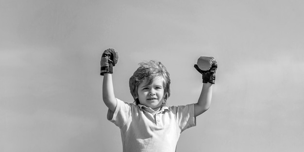 Homme sportif boxe petit garçon dans des gants de boxe rouges noir et blanc