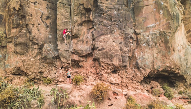 Homme sportif commencer à escalader une paroi rocheuse dans un canyon