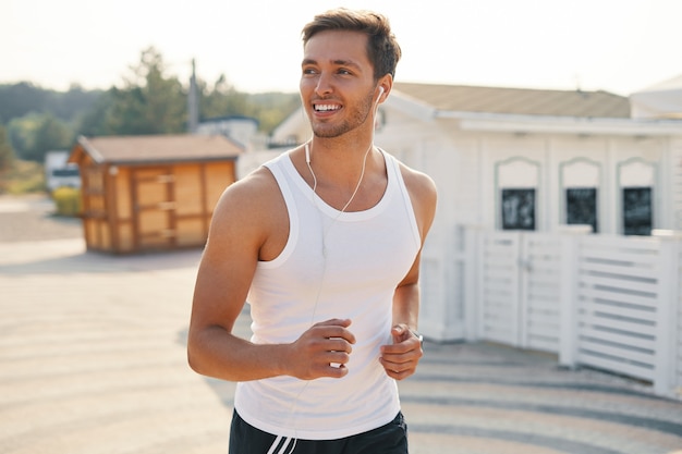 homme sportif avec des écouteurs en cours d'exécution