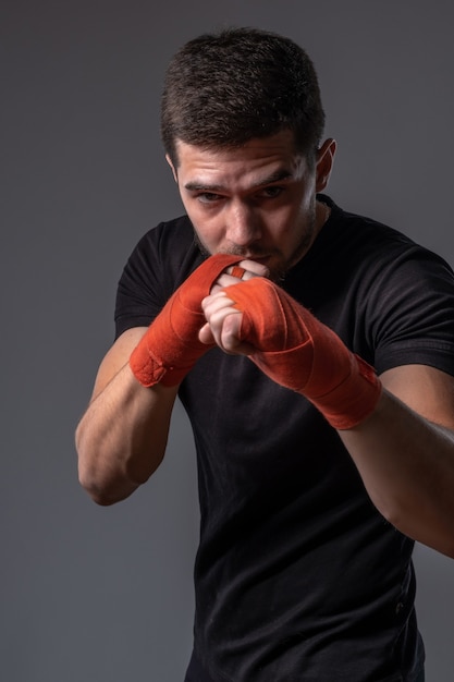 Homme sportif avec des enveloppes de mains debout dans une position de combat orthodoxe