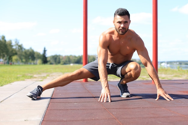 Homme sportif faisant des exercices d'étirement pour les jambes à l'extérieur.