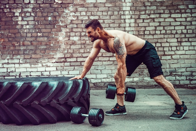 Homme sportif avec un haltère. Force et motivation. Exercice pour les muscles du dos