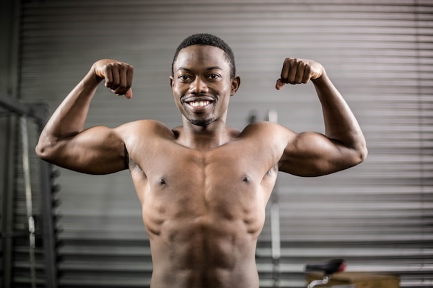 Homme sportif montrant les muscles au gymnase