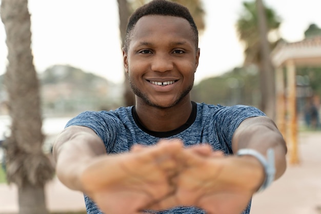 Homme sportif multiracial fort en vêtements de sport se réchauffer et faire de l'exercice d'étirement