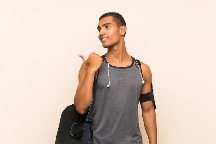 Photo homme sportif pointant sur le côté pour présenter un produit