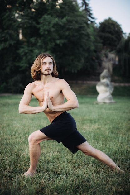 Homme sportif pratiquant le yoga en plein air