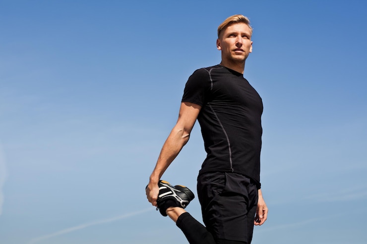Photo homme sportif qui s'étend de la jambe