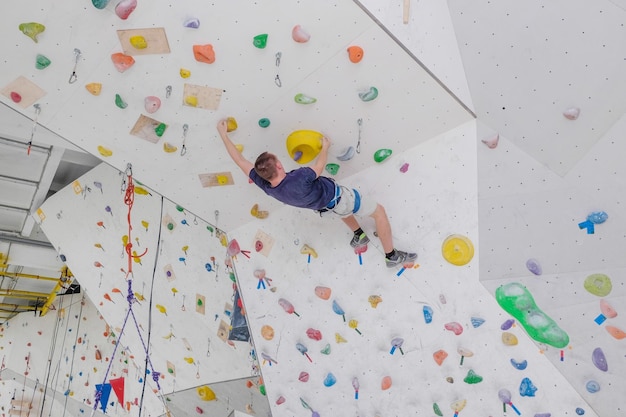 Homme sportif s'élevant sur le mur d'escalade