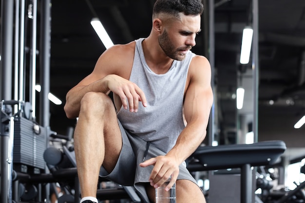 Homme sportif se reposant, ayant bu de l'eau après avoir fait de l'exercice.