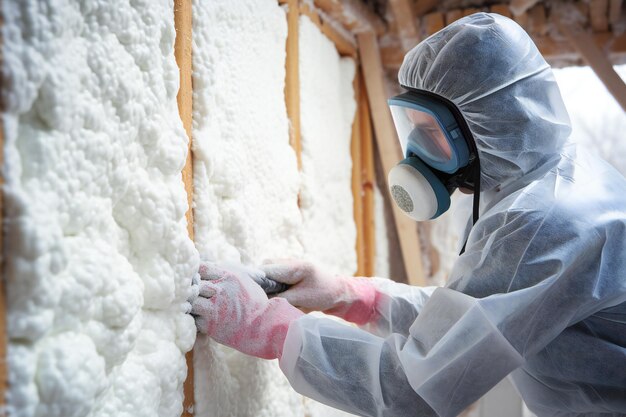 Photo homme stérilisant la mousse isolante des murs de la maison