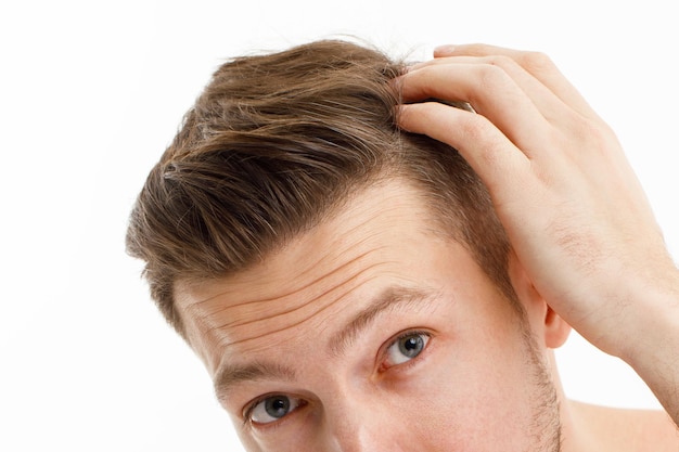 Homme stressé aux cheveux grisonnants regardant dans le miroir