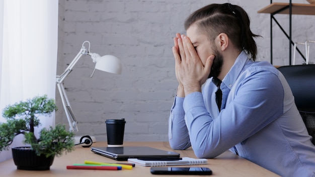 Homme stressé surmené sur ordinateur portable