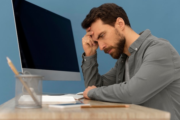 Homme stressé travaillant sur ordinateur