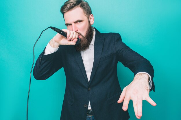 L'homme en suite chante avec un microphone