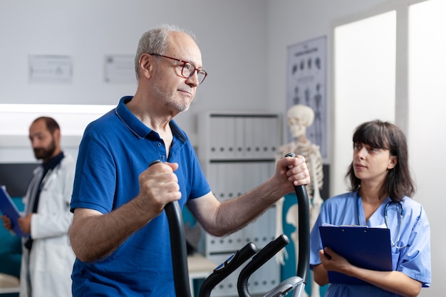 Homme supérieur faisant l'exercice physique pour la récupération orthopédique