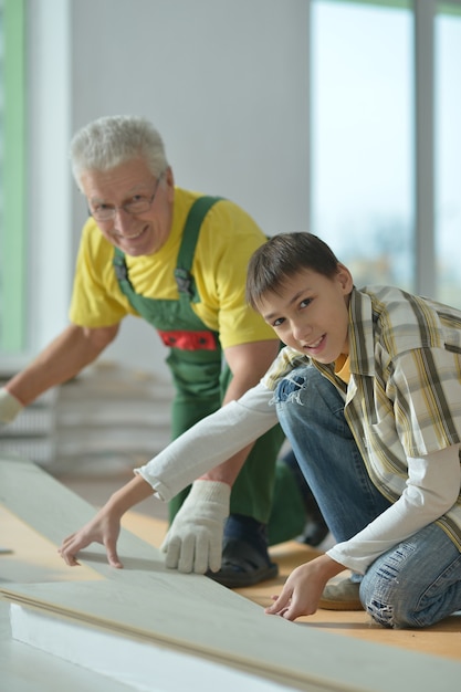 Photo homme supérieur et son petit-fils réparant dans la chambre