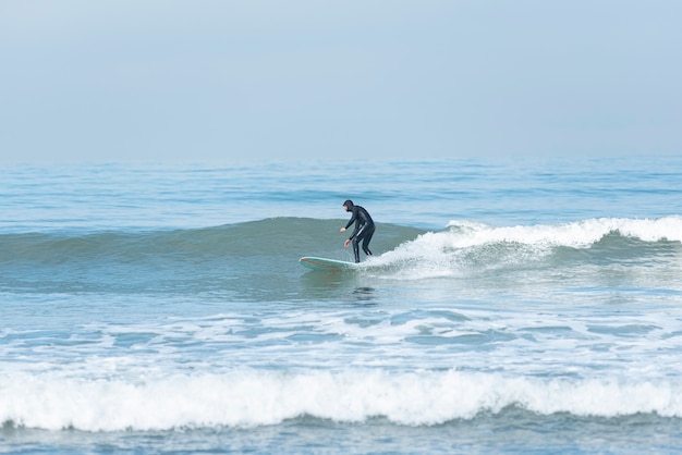 Photo homme surfant sur la vague