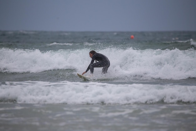 Photo un homme surfe dans la mer contre le ciel