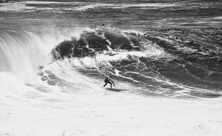 Photo un homme surfe dans la mer.