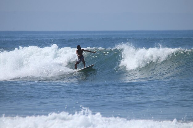 Photo un homme surfe dans la mer.