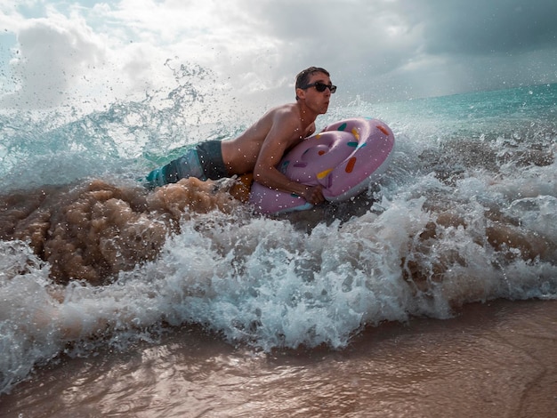 Un homme surfe sur la mer contre le ciel