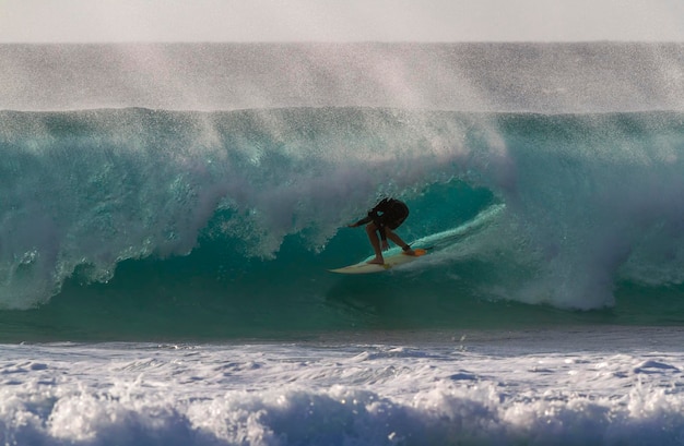 Un homme surfe sur la mer