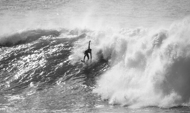 Photo un homme surfe sur la mer