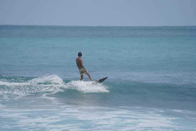 un homme surfe sur la vague sur la plage