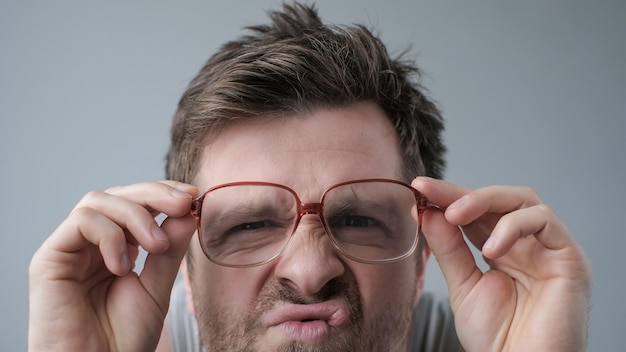 Homme surpris dans de grands verres avec une expression wow sur fond gris