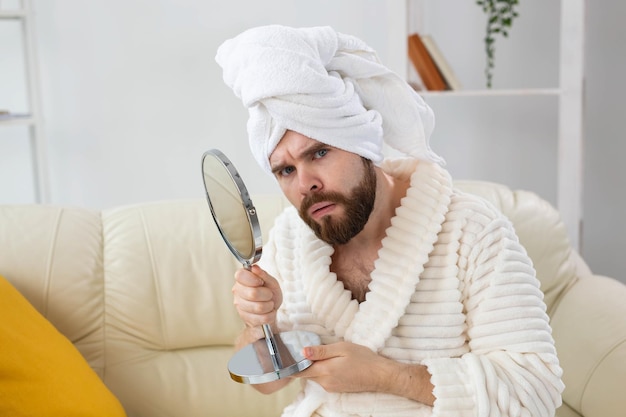 Homme surpris vérifiant sa peau du visage. Spa, soins du corps et de la peau pour le concept masculin.