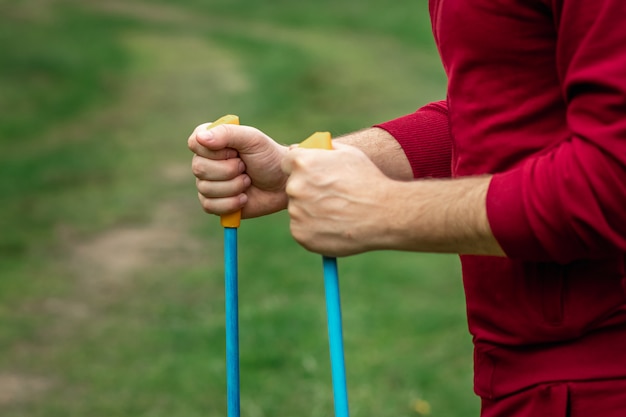 Un homme en survêtement est engagé dans la marche nordique