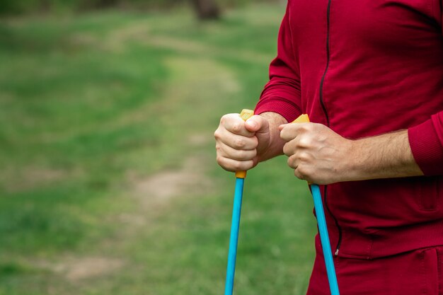 Un homme en survêtement est engagé dans la marche nordique