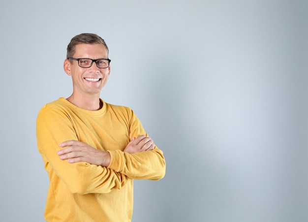 Homme en sweat-shirt jaune élégant sur fond gris espace pour le texte