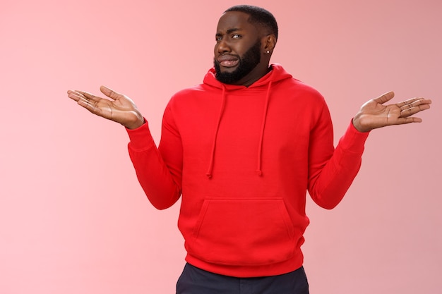 Homme avec un sweat-shirt rouge sur rose