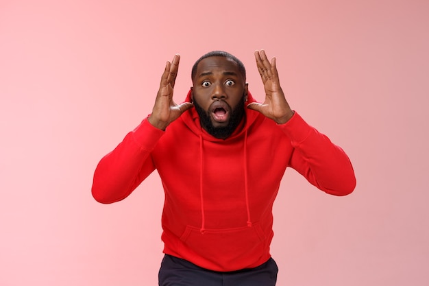 Homme avec un sweat-shirt rouge sur rose