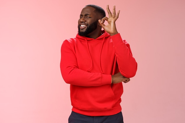 Homme avec un sweat-shirt rouge sur rose