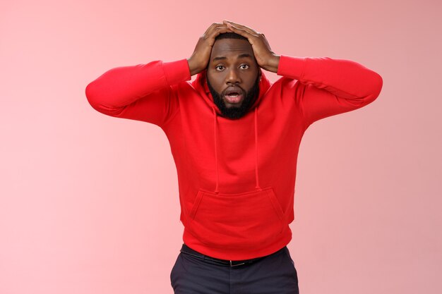 Homme avec un sweat-shirt rouge sur rose