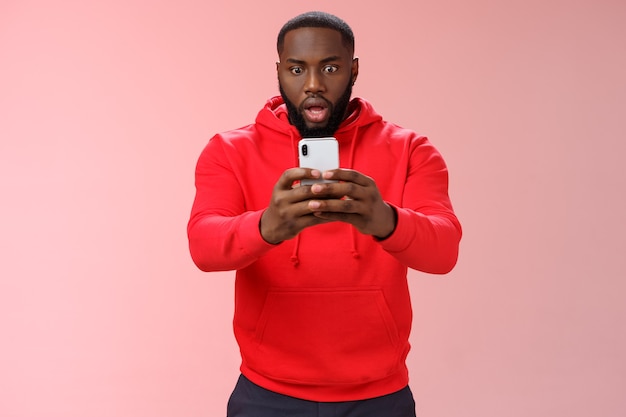 Homme avec un sweat-shirt rouge sur rose