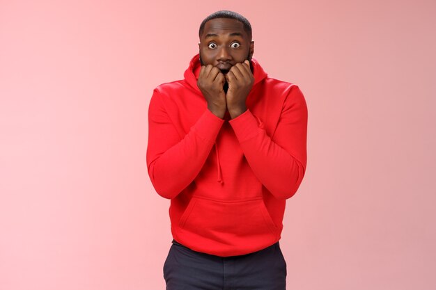 Homme avec un sweat-shirt rouge sur rose