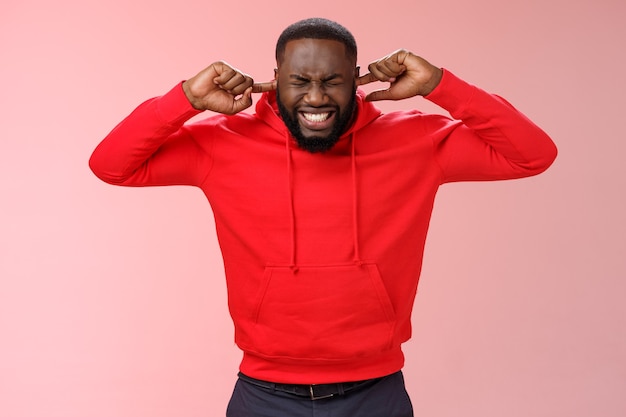 Homme avec un sweat-shirt rouge sur rose