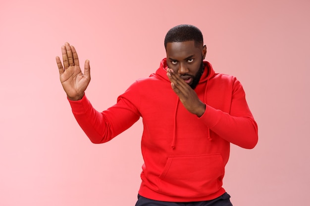 Homme avec un sweat-shirt rouge sur rose