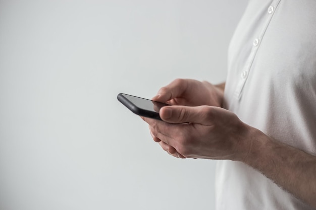 Un homme en T-shirt blanc tenant un téléphone