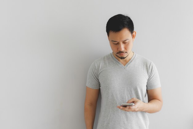 L'homme En T-shirt Gris Utilise Le Smartphone.