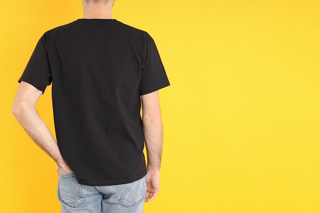 Homme en t-shirt noir vierge sur fond jaune