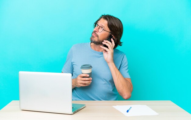 homme sur table sur fond bleu isolé