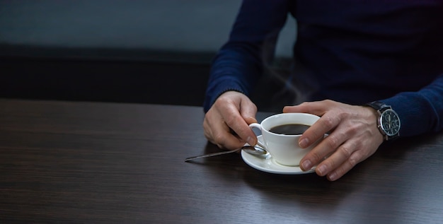 Un homme à la table avec une tasse de café