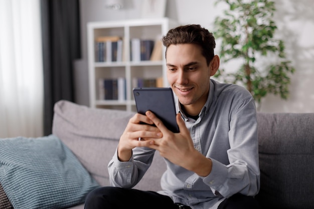 Homme avec tablette sur canapé