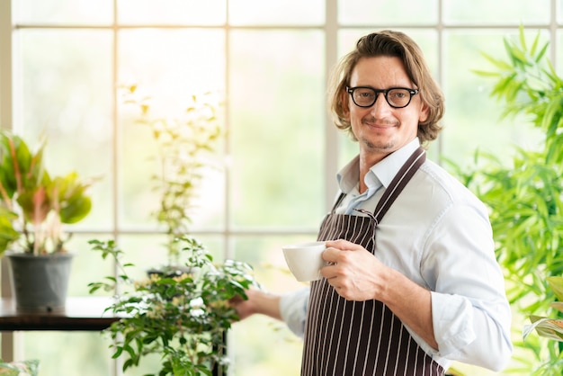 homme, à, tablier, dans, serre, café buvant